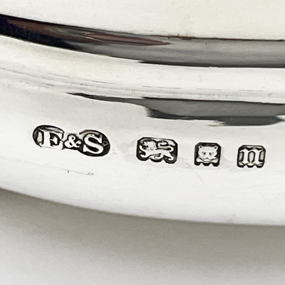 A polished sterling silver tea caddy featuring a lobed body, ropework border trim, domed lid with finial, and four small ball feet. View VIII