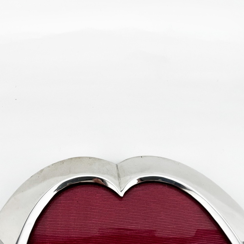 A heart-shaped sterling silver photo frame with a polished border, burgundy velvet backdrop, and an easel support leg. View III