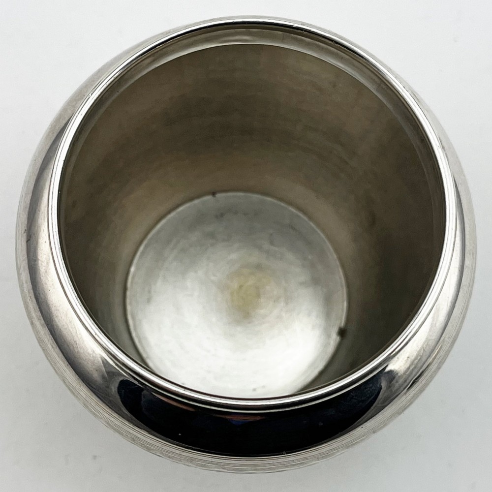 A rounded sterling silver tea caddy featuring a woven engine-turned textured pattern across the body and fitted circular lid, displaying British hallmarks. View V