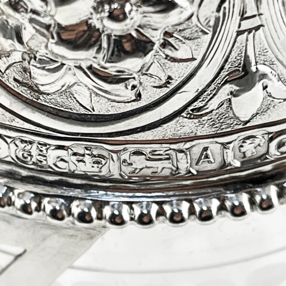 A Victorian sterling silver-mounted clear glass claret jug with floral glass etching, chased silver neck collar, and angular silver handle. View IX