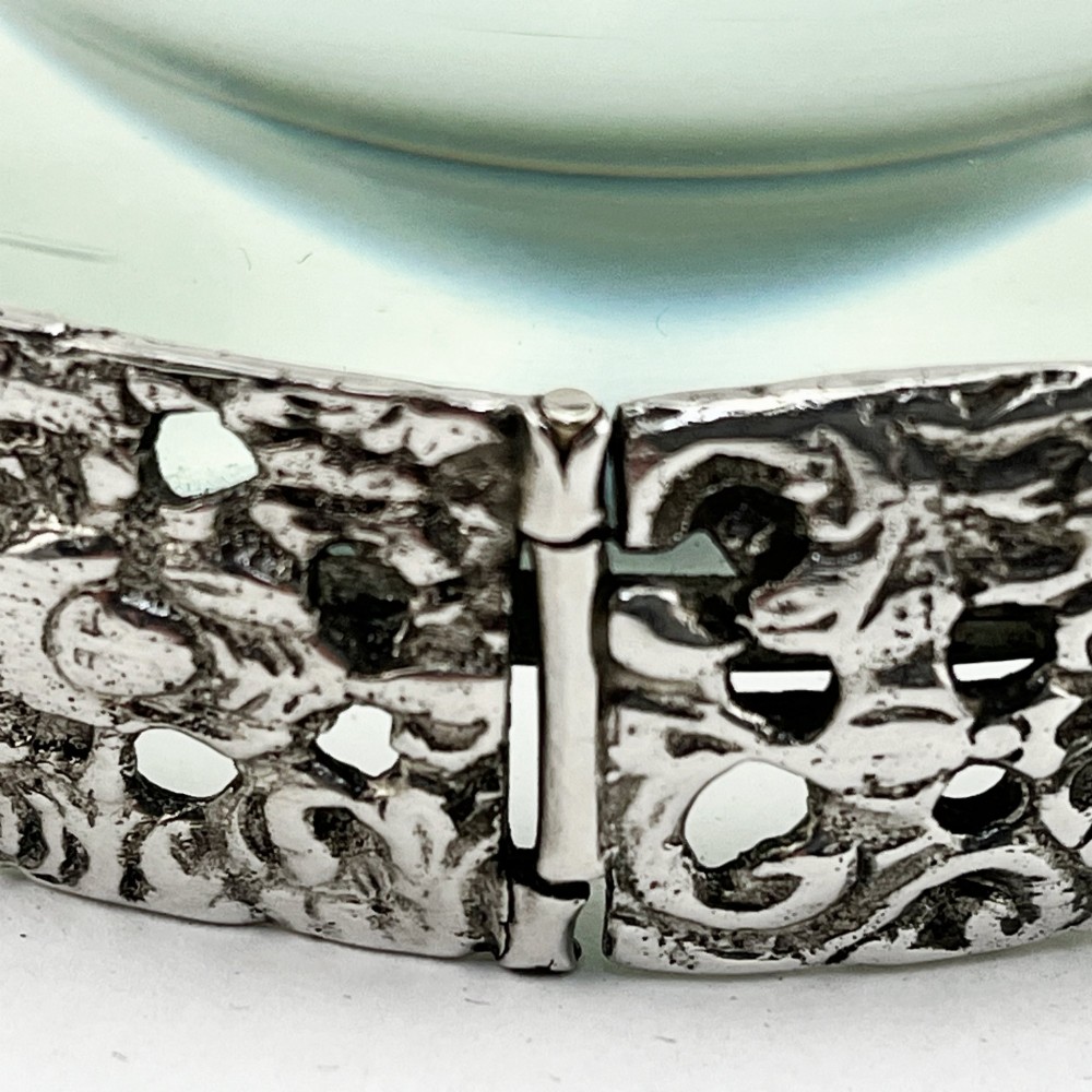 An antique Victorian sterling silver magnifying glass featuring an intricately chased handle and a pierced decorative circular silver rim. View IV
