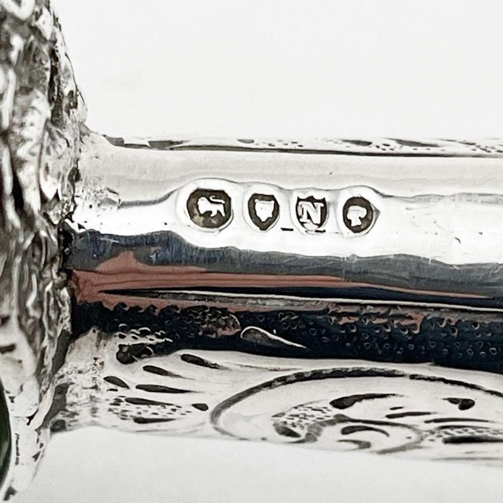 An antique Victorian sterling silver magnifying glass featuring an intricately chased handle and a pierced decorative circular silver rim. View VI