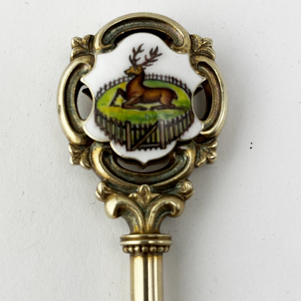 An antique sterling silver presentation key with a stag enamel crest displayed inside its original velvet-lined presentation box. View III