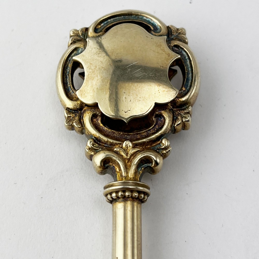 An antique sterling silver presentation key with a stag enamel crest displayed inside its original velvet-lined presentation box. View IV