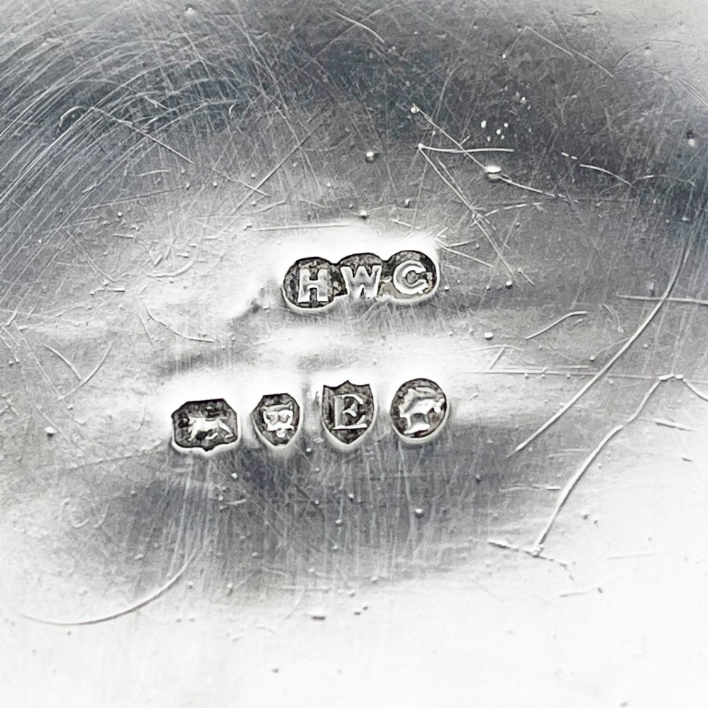 A rectangular Victorian sterling silver trinket box decorated with detailed repousse cherubs and floral scrolls, supported by four ball feet. View VIII