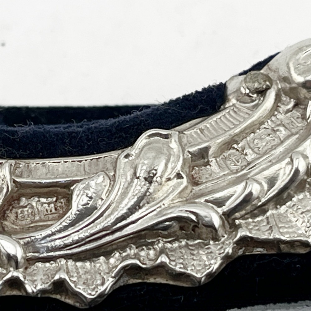 An ornate Edwardian sterling silver picture frame featuring chased floral scrollwork, a blank top cartouche, and a dark velvet mount with a central circular aperture. View VII