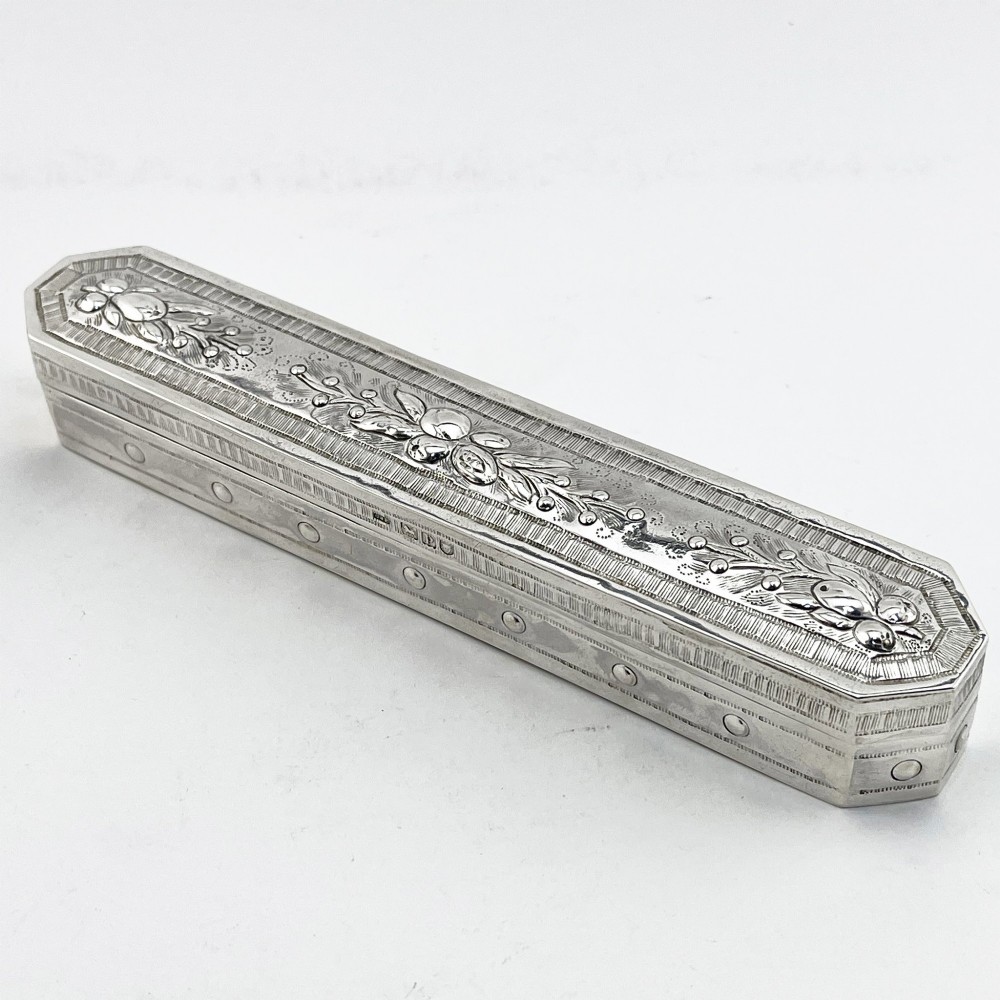 An elongated Edwardian sterling silver trinket box featuring embossed leaf motifs and visible hallmarks along the side.