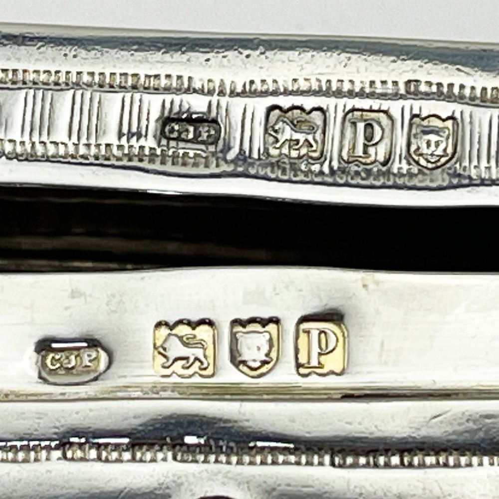 An elongated Edwardian sterling silver trinket box featuring embossed leaf motifs and visible hallmarks along the side. View V