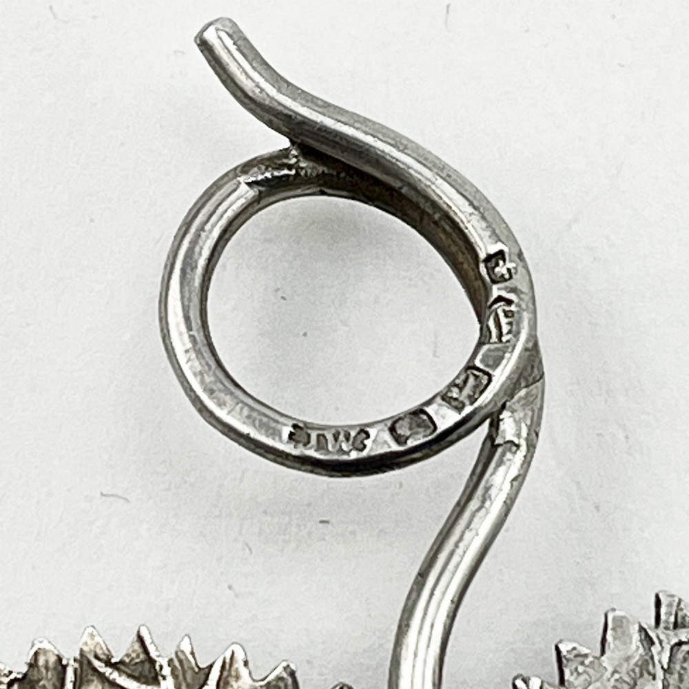 A Georgian sterling silver tea caddy spoon fashioned in the shape of a serrated leaf with engraved vein detailing and a coiled ring handle. View IV
