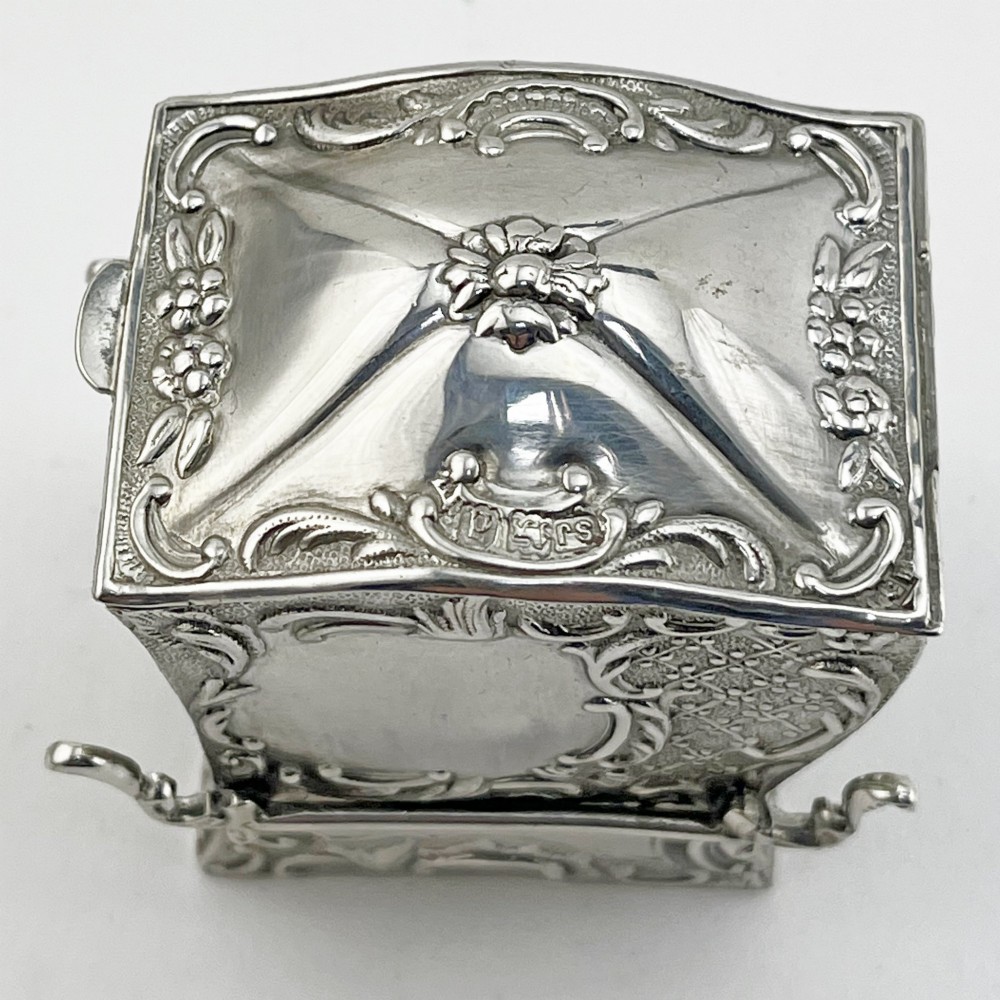 A Victorian sterling silver playing card case designed in the form of a sedan chair with embossed floral and scroll motifs. View II