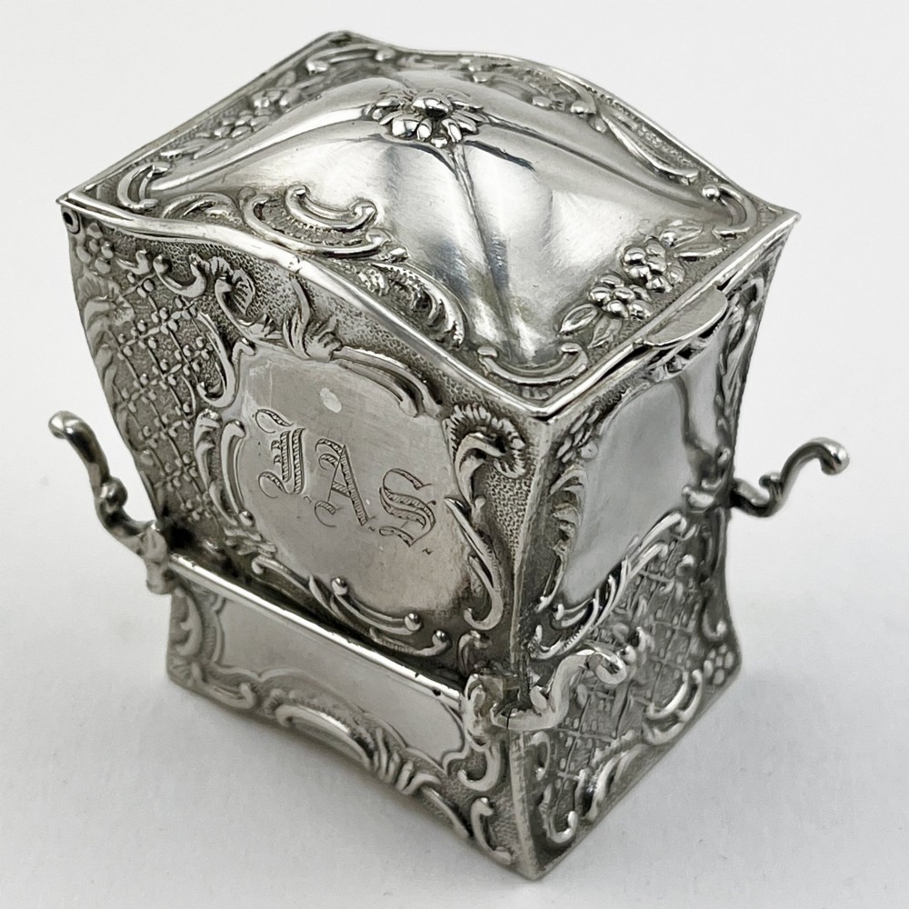 A Victorian sterling silver playing card case designed in the form of a sedan chair with embossed floral and scroll motifs. View III