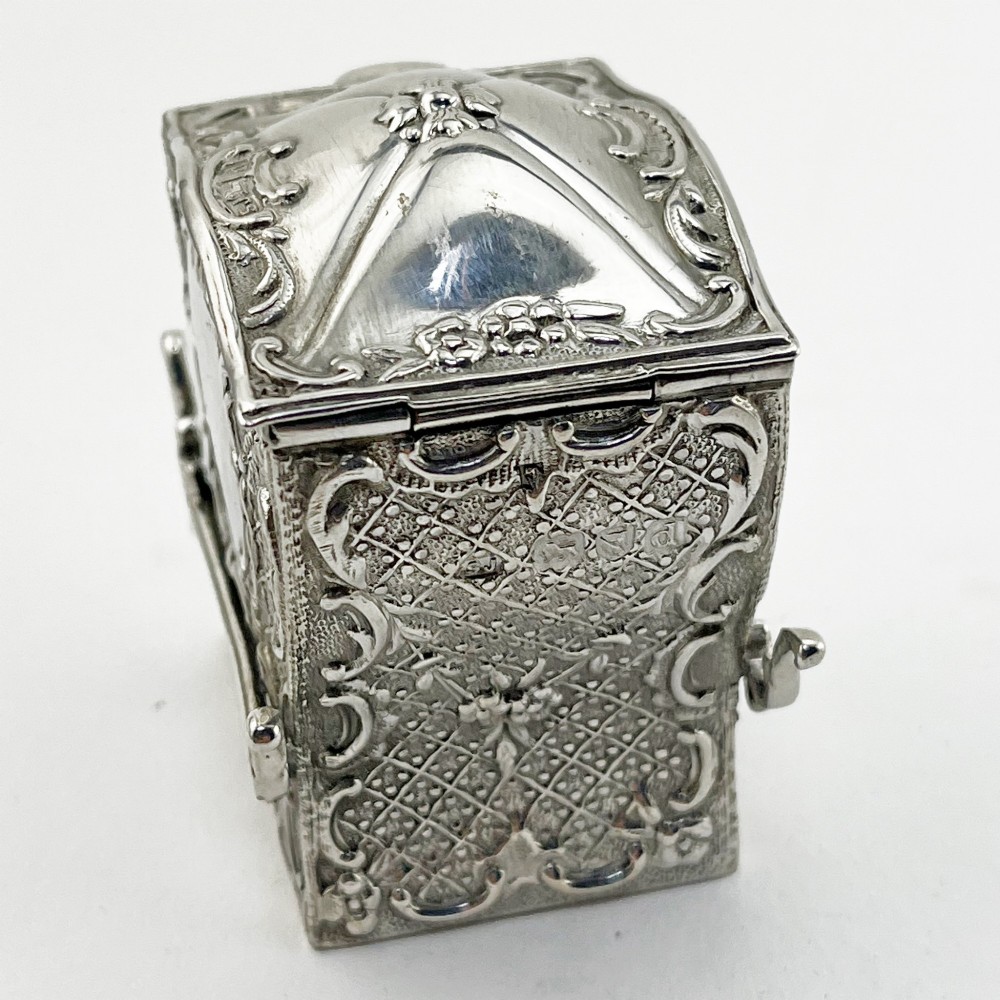 A Victorian sterling silver playing card case designed in the form of a sedan chair with embossed floral and scroll motifs. View IV