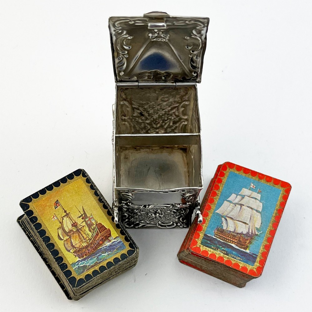 A Victorian sterling silver playing card case designed in the form of a sedan chair with embossed floral and scroll motifs. View V