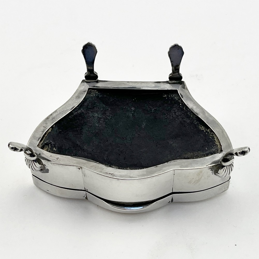 A polished sterling silver trinket box featuring a contoured lid and four shell-motif feet. View VII