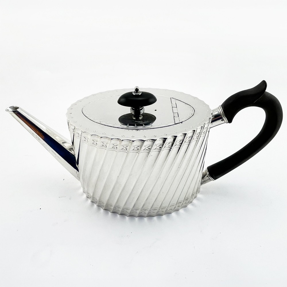 A four-piece Victorian silver-plated tea and coffee set featuring diagonal fluted body detailing and ebonised handles. View II