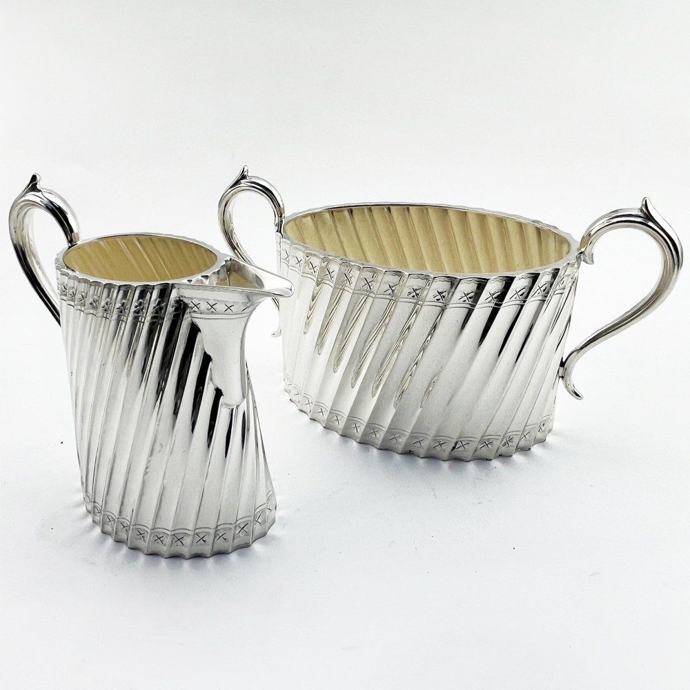 A four-piece Victorian silver-plated tea and coffee set featuring diagonal fluted body detailing and ebonised handles. View IV