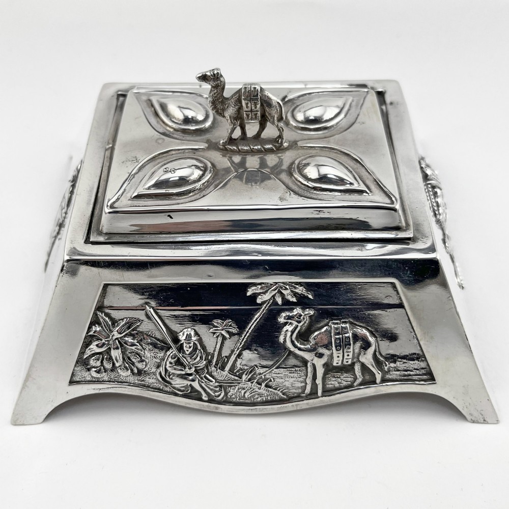 A square sterling silver trinket casket featuring a camel finial on the lid and detailed desert relief panels along the sides.