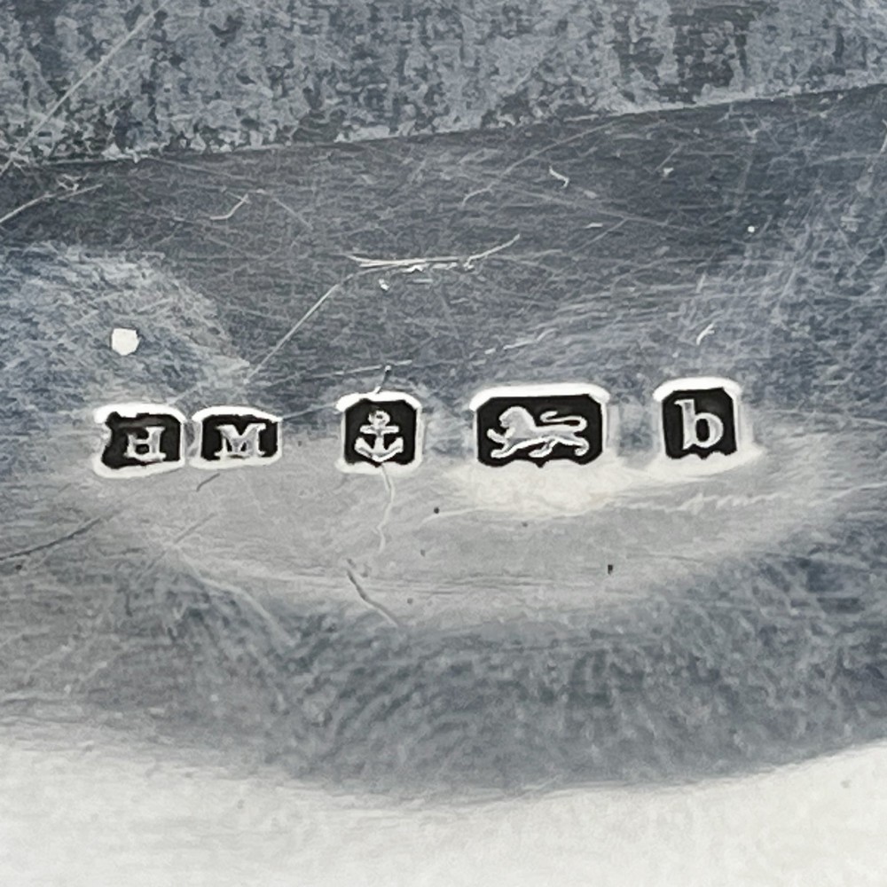 An Edwardian sterling silver trinket box featuring a raised relief depiction of a mother embracing a child on the hinged lid, set on scrolled silver feet. View VIII