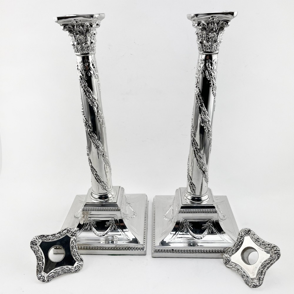 A pair of silver-plated column candlesticks featuring Corinthian capitals, spiral foliate garlands along the shafts, and square stepped bases. View III