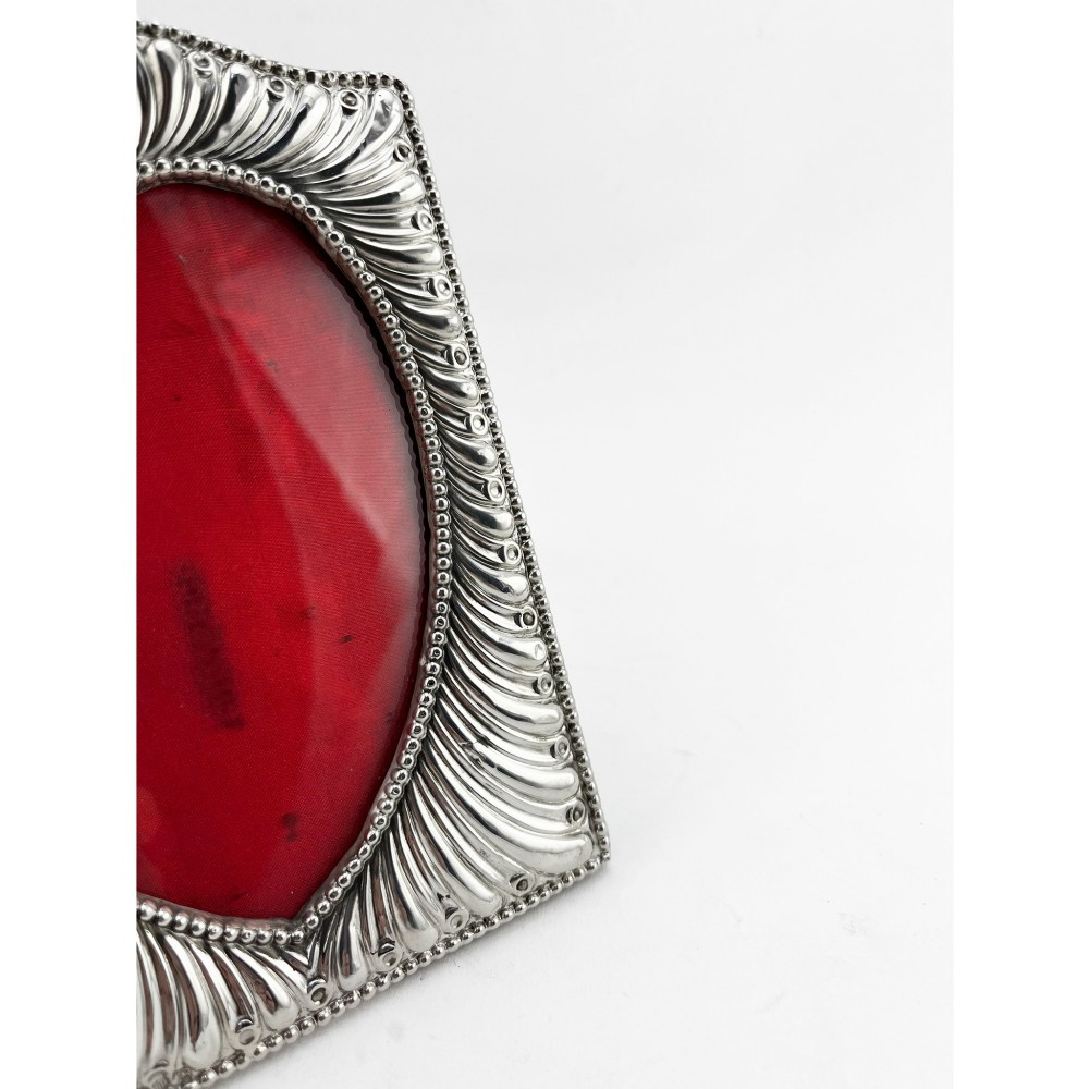 A Victorian sterling silver photo frame featuring repousse fluted patterns, a beaded border, and a heart-shaped picture aperture with a red fabric interior. View II