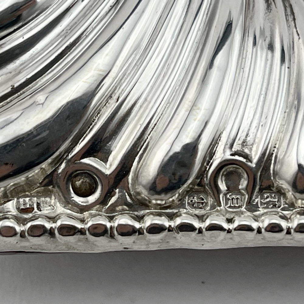 A Victorian sterling silver photo frame featuring repousse fluted patterns, a beaded border, and a heart-shaped picture aperture with a red fabric interior. View VI