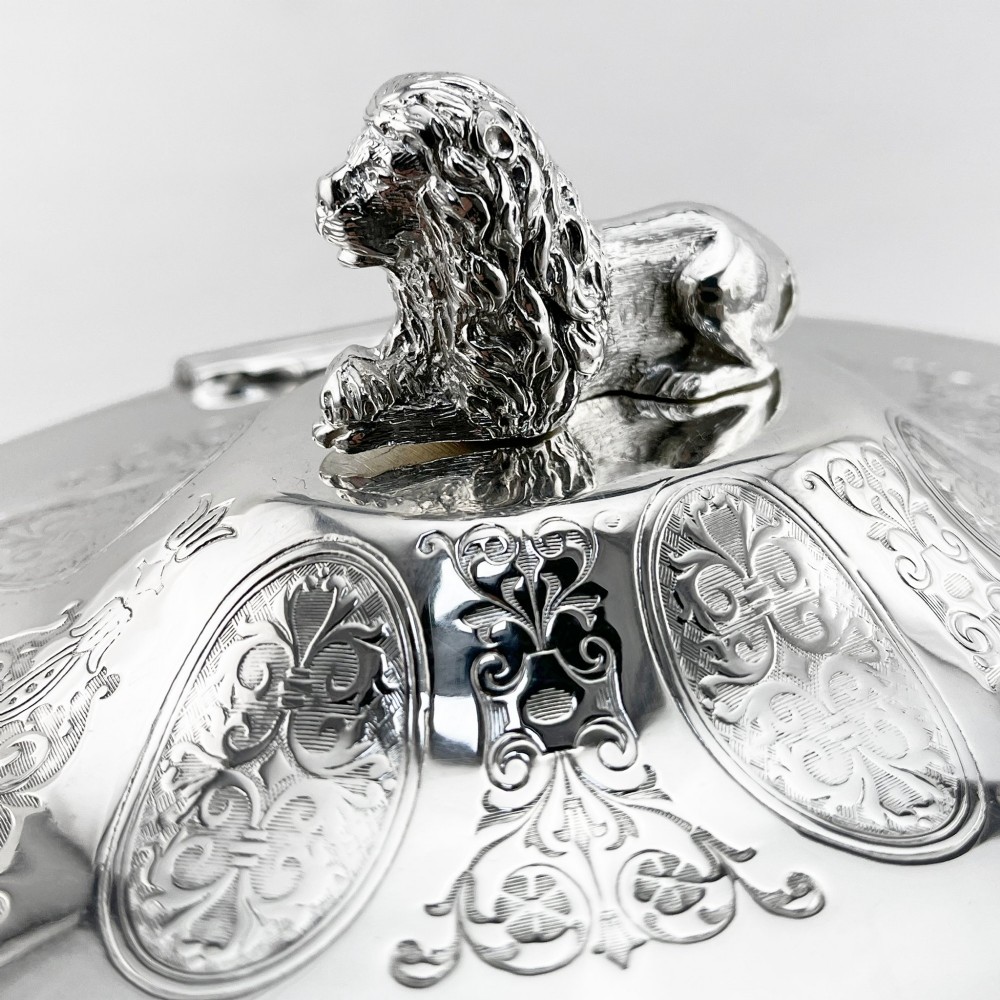 An oval Victorian silver-plated biscuit box featuring reticulated fretwork sides, an engraved lid with a dog finial, and a beaded footed base. View II