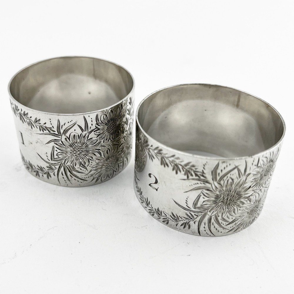 A pair of engraved Victorian sterling silver napkin rings numbered 1 and 2 inside a fitted velvet display case. View III