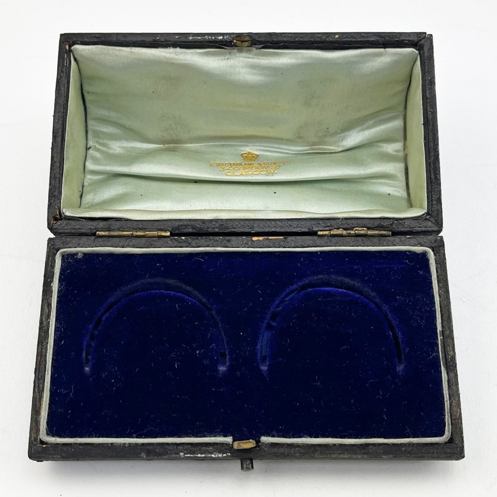 A pair of engraved Victorian sterling silver napkin rings numbered 1 and 2 inside a fitted velvet display case. View V