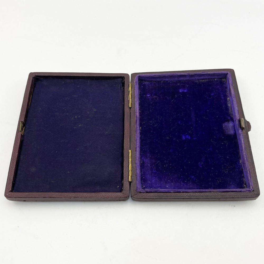 An engraved Victorian sterling silver visiting card case with ivy foliage patterning, seated inside a purple velvet-lined presentation box. View VIII