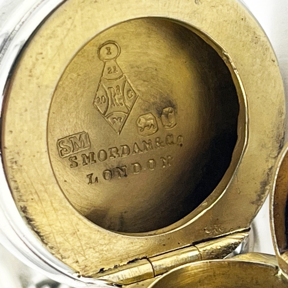A Victorian sterling silver horn-shaped scent bottle with attached chain links and stamped British hallmarks. View V