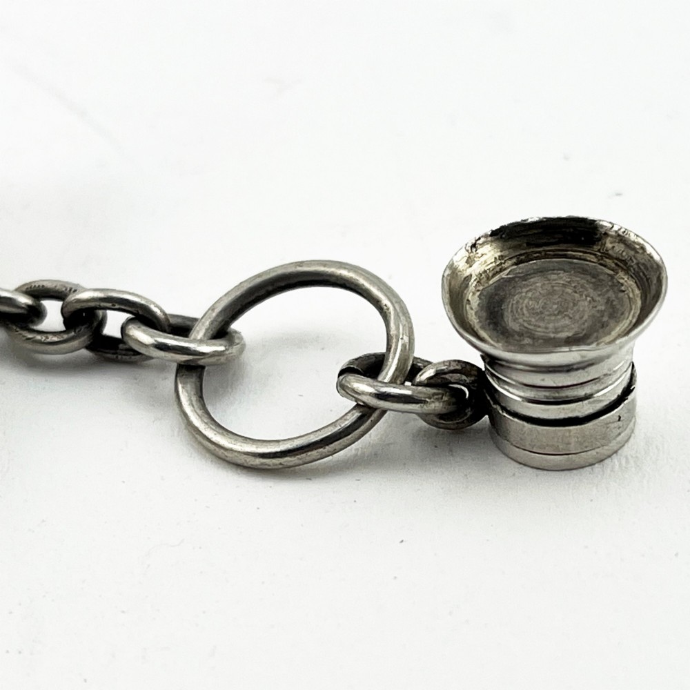 A Victorian sterling silver horn-shaped scent bottle with attached chain links and stamped British hallmarks. View VIII