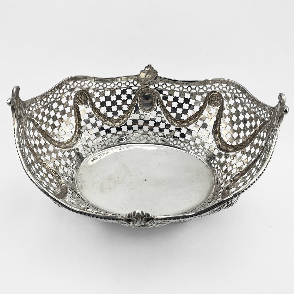 A boat-shaped sterling silver pierced dish with decorative swags, bead borders, and shell-motif feet. View II