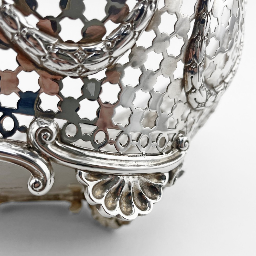 A boat-shaped sterling silver pierced dish with decorative swags, bead borders, and shell-motif feet. View VI