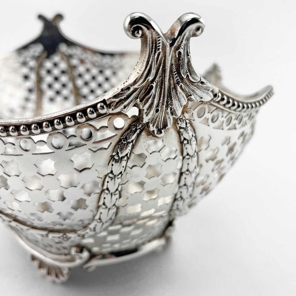 A boat-shaped sterling silver pierced dish with decorative swags, bead borders, and shell-motif feet. View VII