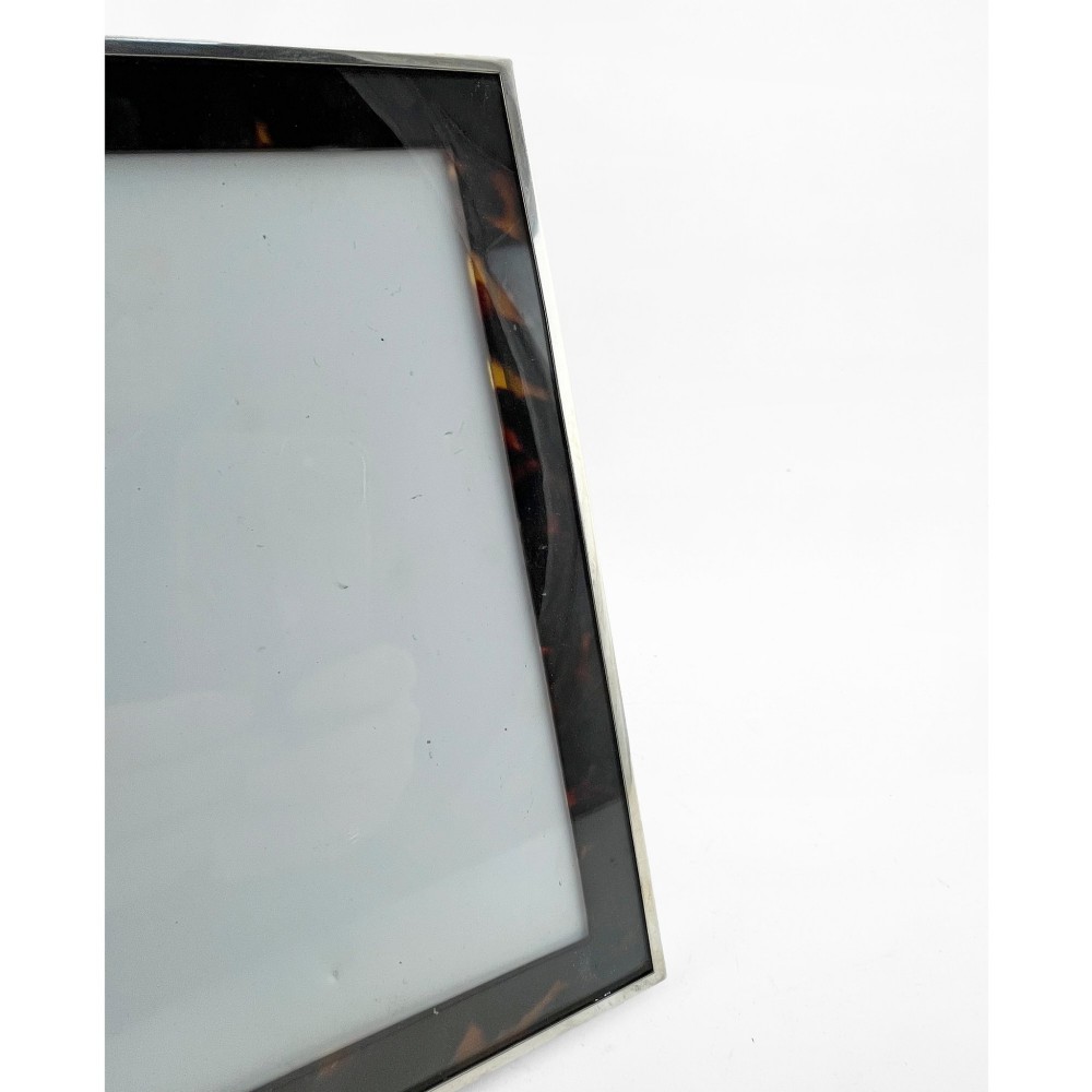 A rectangular picture frame with a mottled brown tortoiseshell border encased within a slim sterling silver outer rim. View II