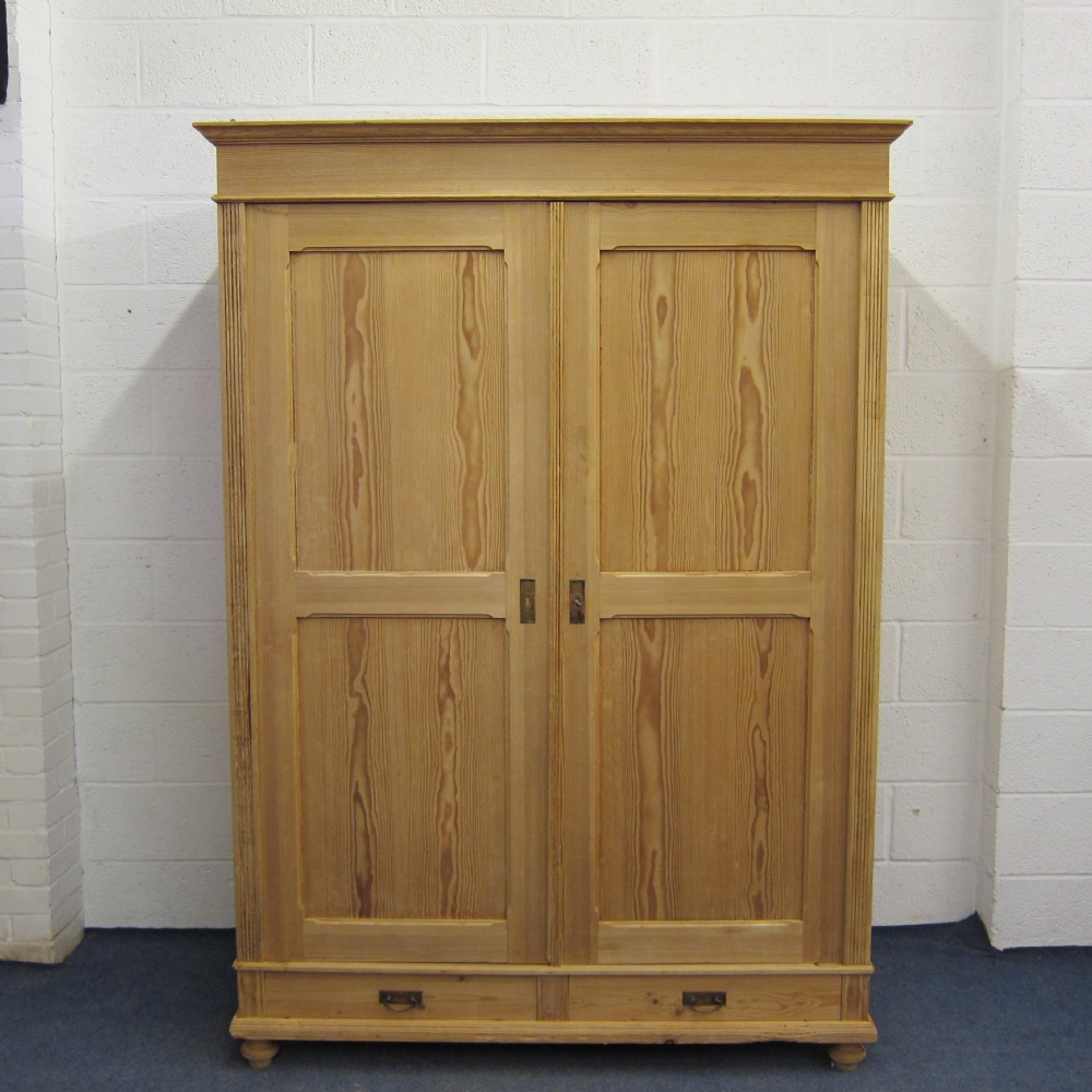 Large antique pine double wardrobe with bottom drawers