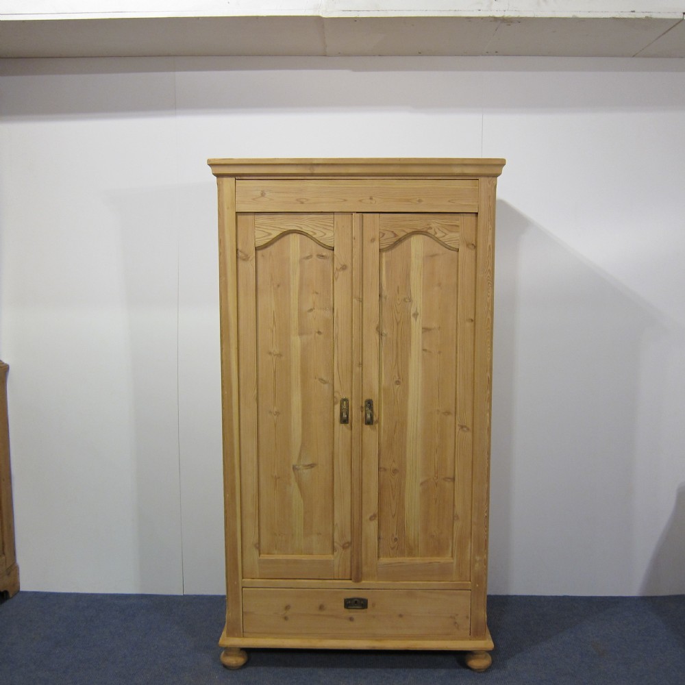 A large Danish antique pine cupboard with a bottom drawer