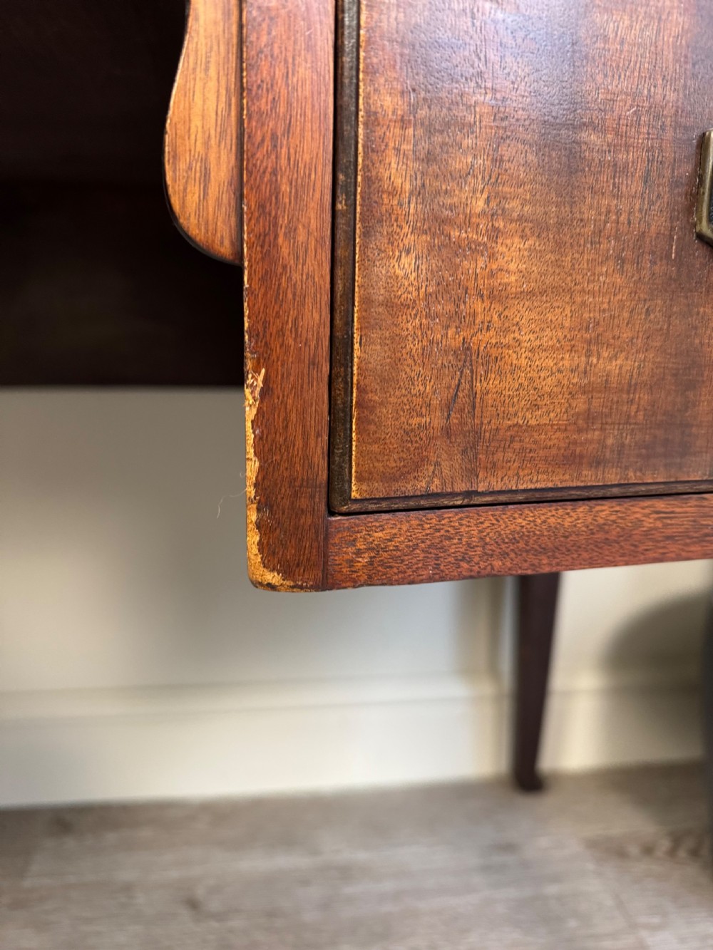 An Edwardian solid mahogany dressing table with brass drop handles, multiple drawers, a kneehole apron, and tapered legs. View IV