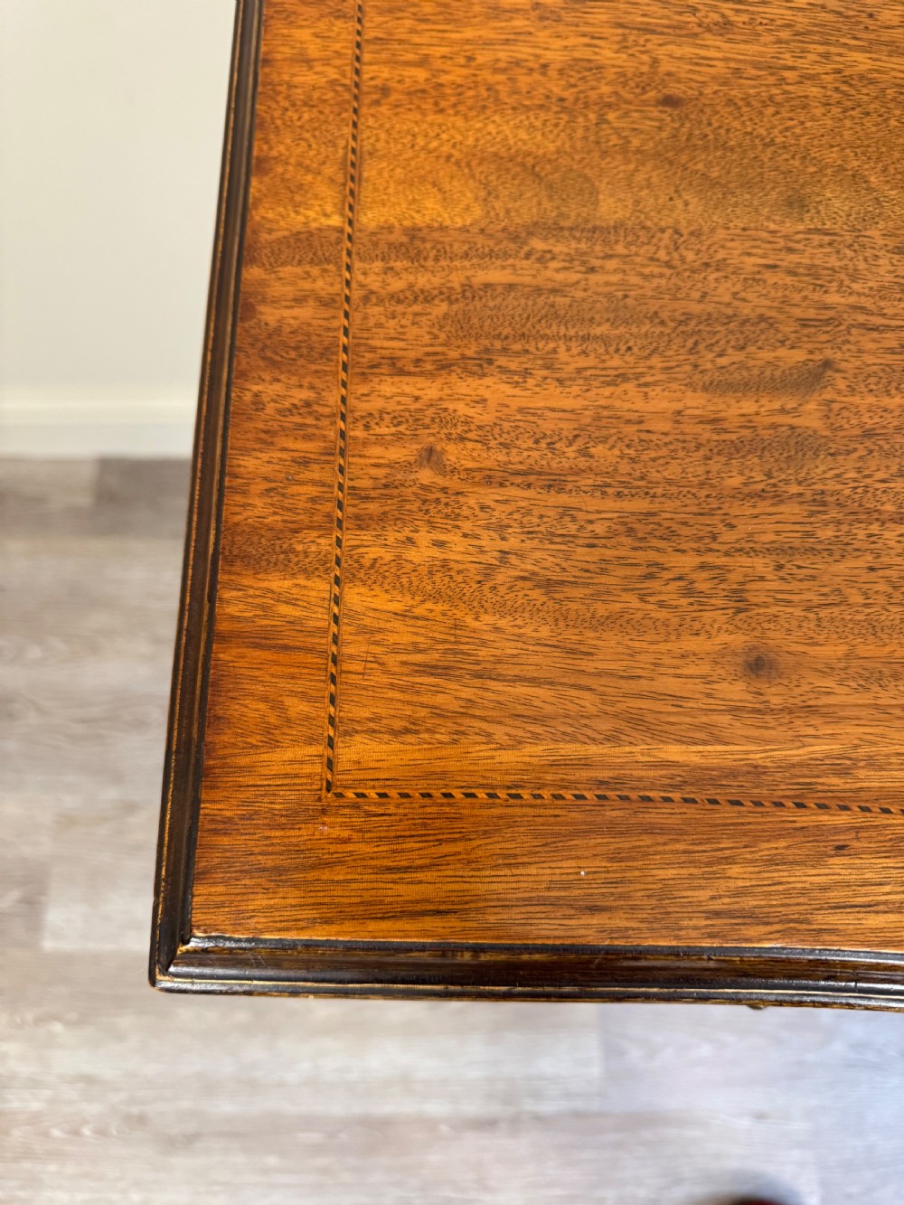An Edwardian solid mahogany dressing table with brass drop handles, multiple drawers, a kneehole apron, and tapered legs. View IX