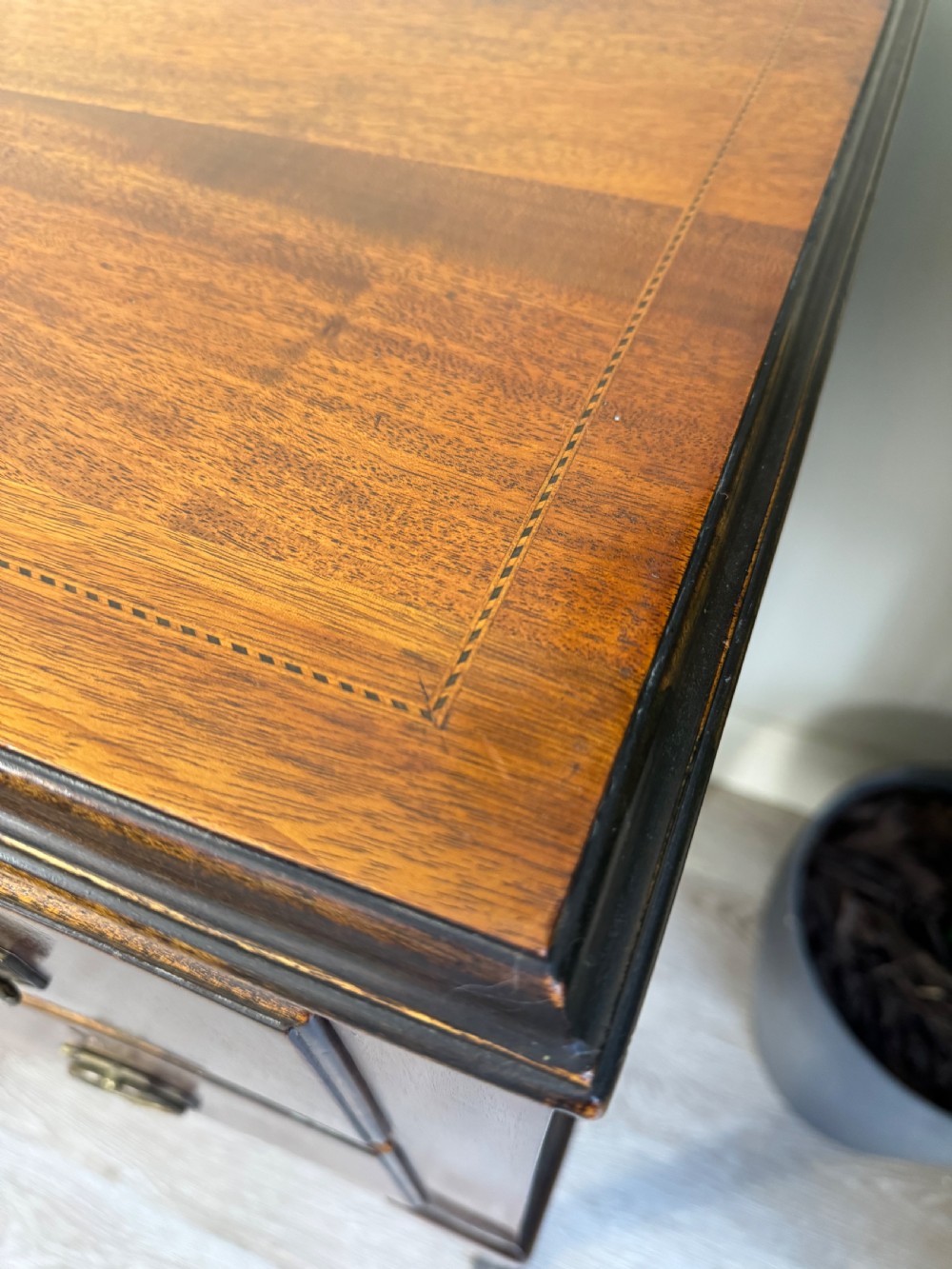 An Edwardian solid mahogany dressing table with brass drop handles, multiple drawers, a kneehole apron, and tapered legs. View X