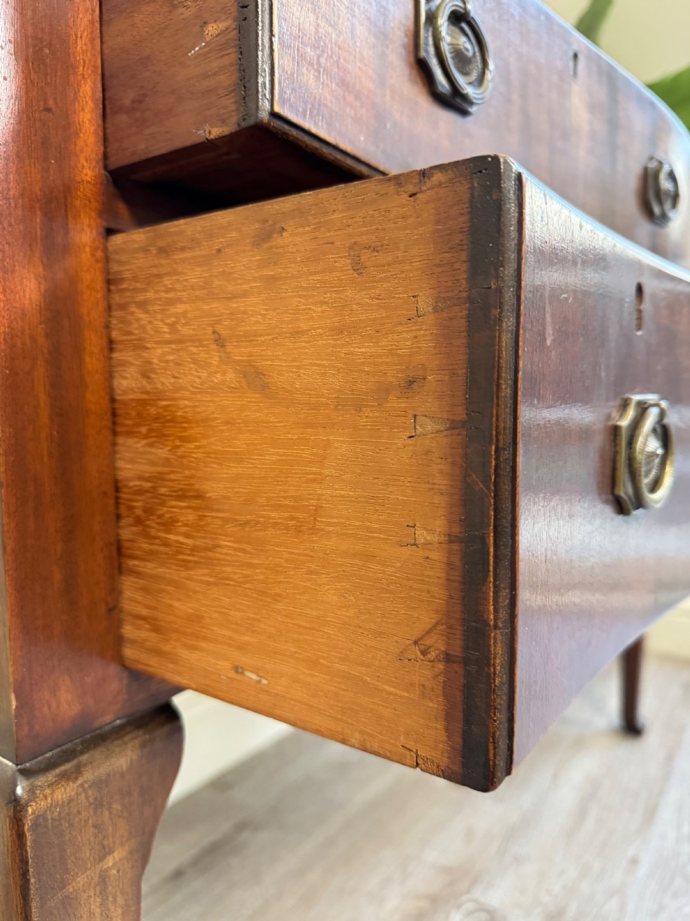 An Edwardian solid mahogany dressing table with brass drop handles, multiple drawers, a kneehole apron, and tapered legs. View XII