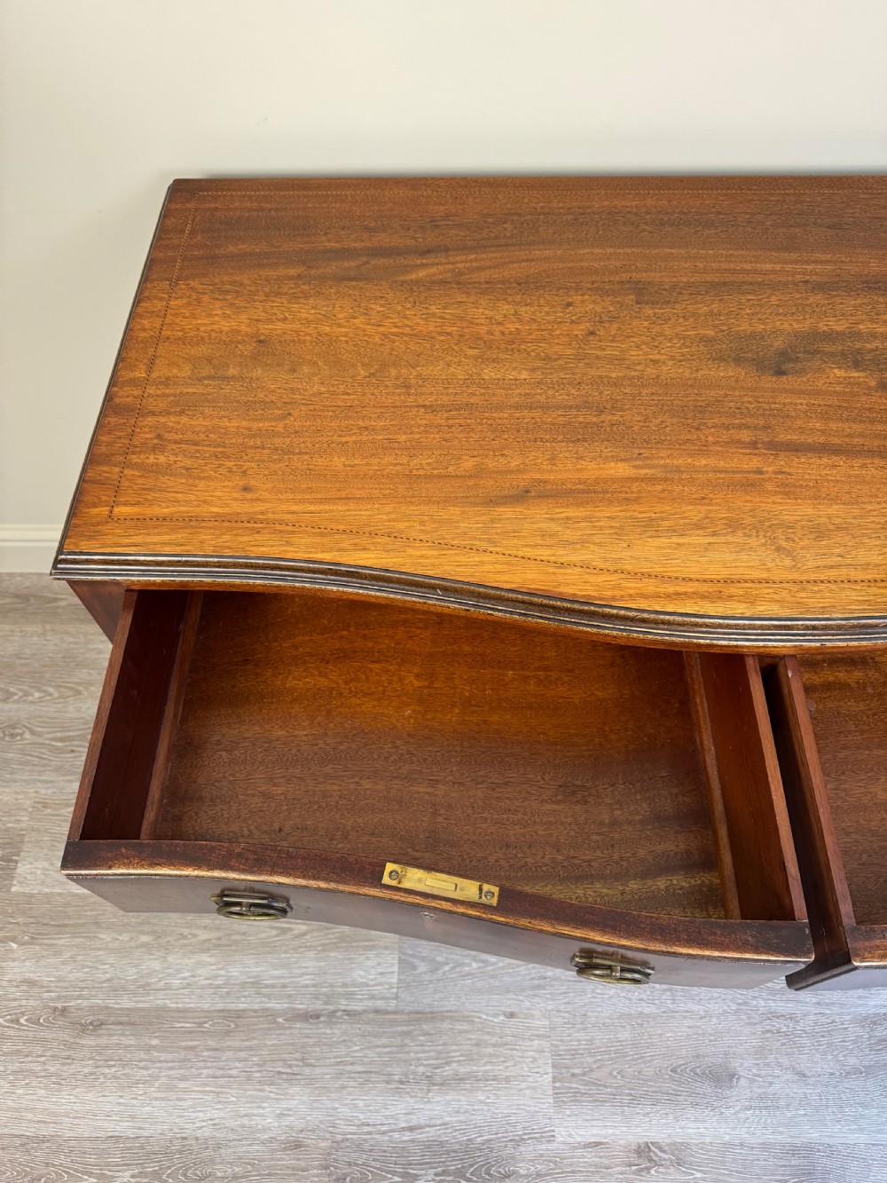 An Edwardian solid mahogany dressing table with brass drop handles, multiple drawers, a kneehole apron, and tapered legs. View XIII