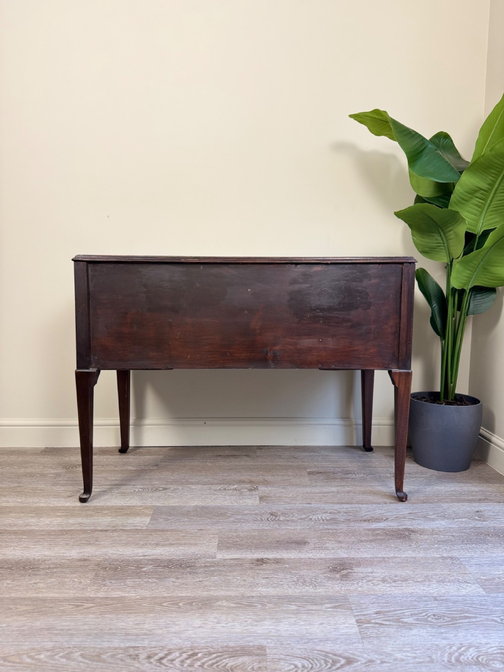 An Edwardian solid mahogany dressing table with brass drop handles, multiple drawers, a kneehole apron, and tapered legs. View XVI