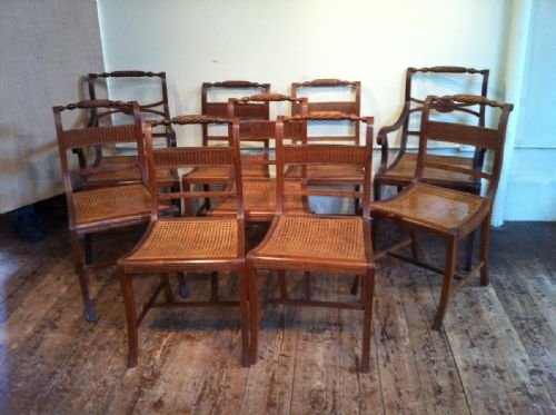 A Set of 11 Anglo Indian Teak Dining Chairs C 1890 in Regency Style with Caned Seats and Squab Cushions

