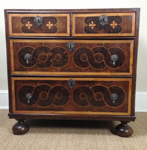 fig 1. A small and rare William and Mary oyster veneered walnut and laburnum cross banded chest of two short and two long drawers c 1695 on later bun feet.