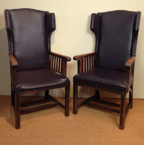 A Pair of Arts and Crafts Oak and Rexine Wing Chairs C 1910