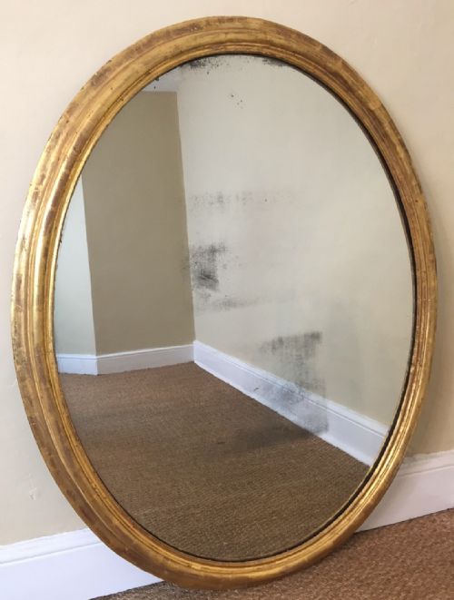A Large Late Regency Gilt Oval Mirror Circa 1830 with Original Silvered Mercury Plate and Panel Back.