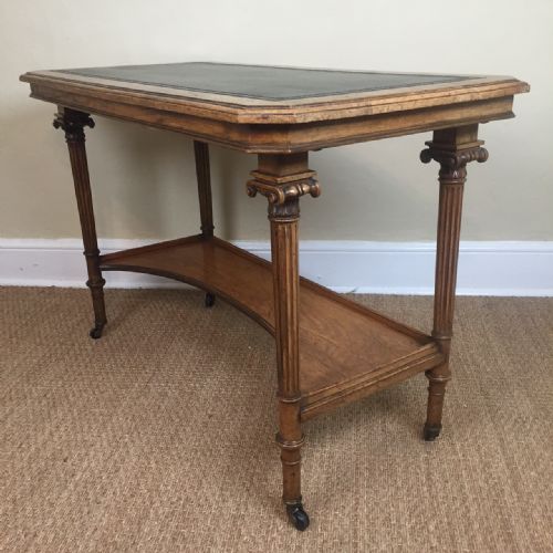 An Unusual Victorian Walnut Writing Table Circa 1890 with Finely Carved Corinthian Capitals to the Top of the Fluted Legs Which Are United by a Platform with Concave Front . Bearing a Brass Plaque to the Underside Inscribed Frank Giles Upholsterers Kensington High Street.
