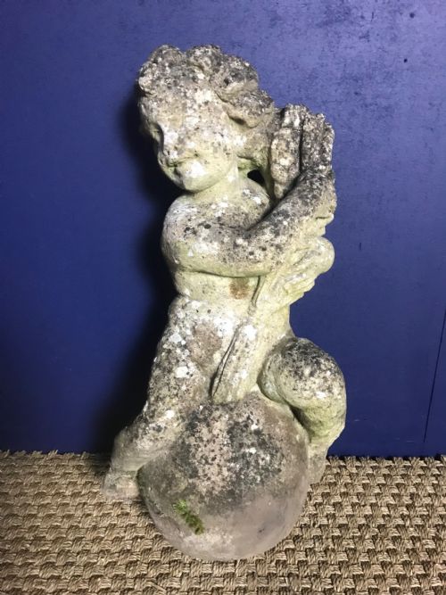 A Composite Stone Figure of a Putto and a Dolphin . English Circa 1920