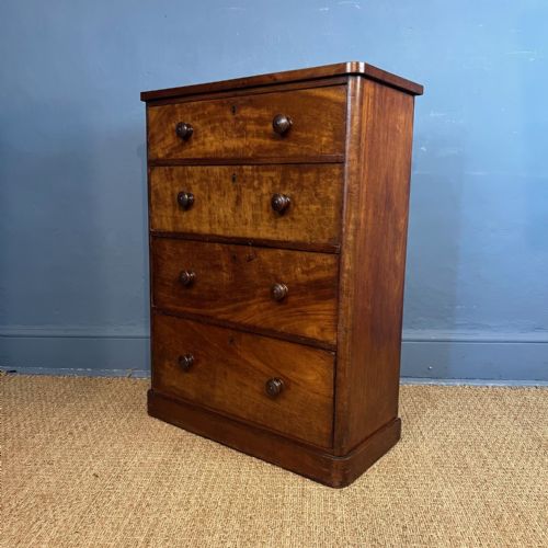 fig 1. A mid-19th-century mahogany chest of drawers featuring four long graduated drawers with turned wooden handles and a solid plinth base.